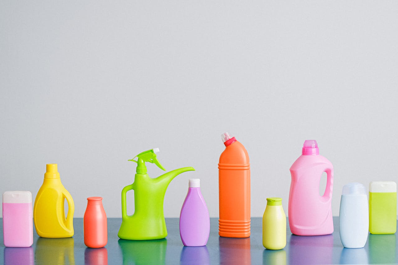 gallery-6 Arrangement of colorful plastic bottles with assorted cleaning products for household placed on table in row against white background in light studio